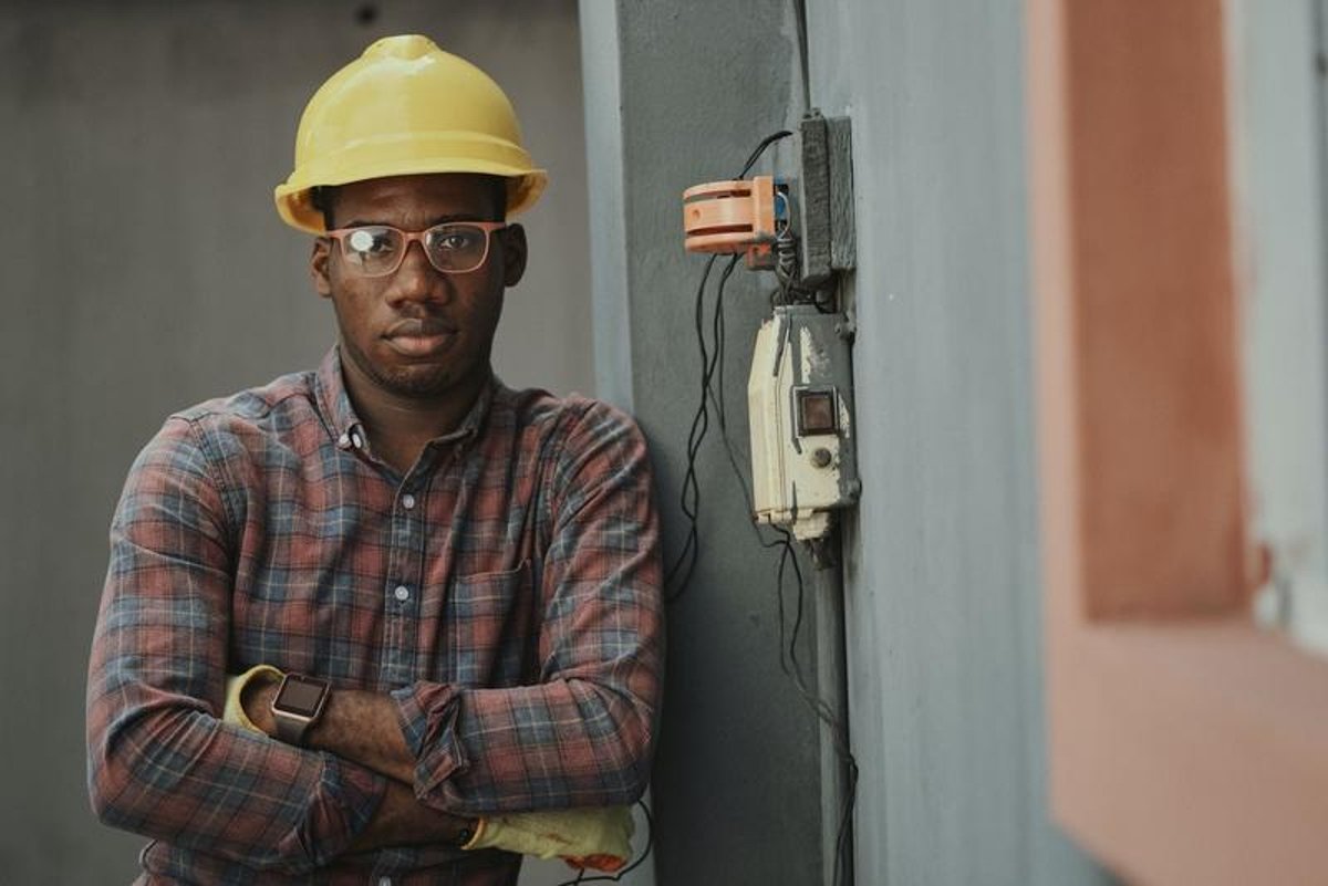 African construction worker wearing a safety helmet at a construction site in Sweden