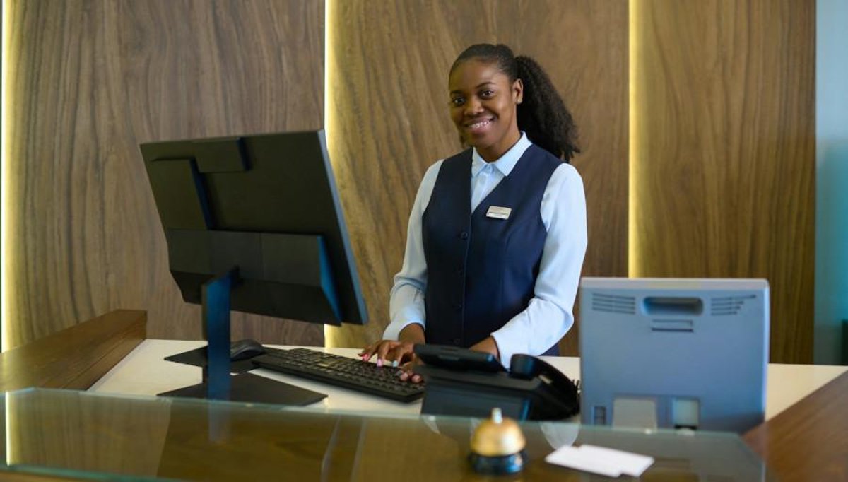 African female hotel receptionist working at a hotel front desk in Ireland
